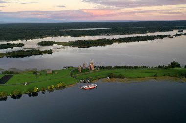 Gölün panoramik manzarası. Birinde ahşaptan yapılmış antik bir tapınak var.