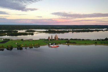 Gölün panoramik manzarası. Birinde ahşaptan yapılmış antik bir tapınak var.