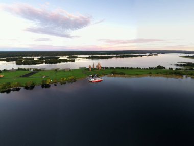 Gölün panoramik manzarası. Birinde ahşaptan yapılmış antik bir tapınak var.