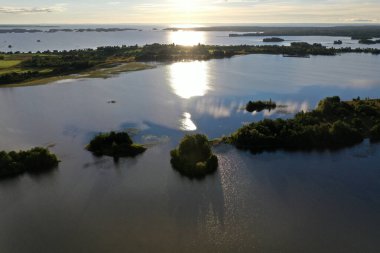 Gölün panoramik manzarası. Birinde ahşaptan yapılmış antik bir tapınak var.