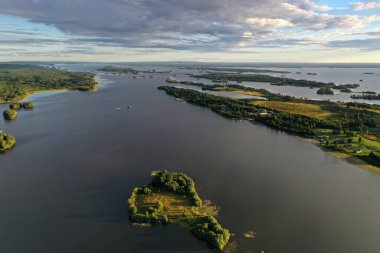 Gölün panoramik manzarası. Birinde ahşaptan yapılmış antik bir tapınak var.