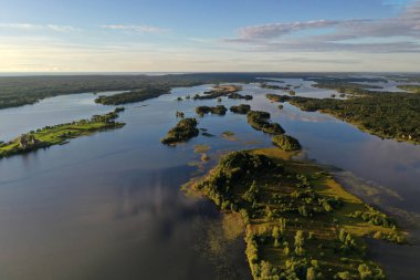Gölün panoramik manzarası. Birinde ahşaptan yapılmış antik bir tapınak var.
