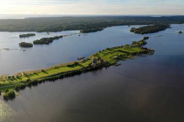 Gölün panoramik manzarası. Birinde ahşaptan yapılmış antik bir tapınak var.