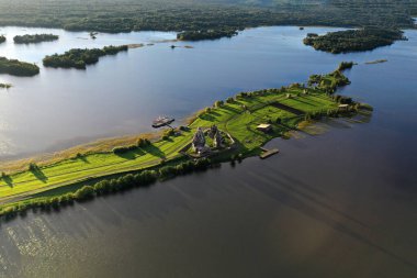 Gölün panoramik manzarası. Birinde ahşaptan yapılmış antik bir tapınak var.