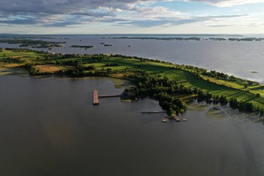 Gölün panoramik manzarası. Birinde ahşaptan yapılmış antik bir tapınak var.