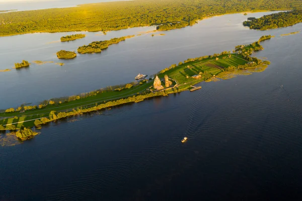 Gölün panoramik manzarası. Birinde bir sürü ada var. Gün batımında ahşaptan yapılmış eski bir tapınak var.