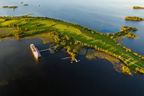Gölün panoramik manzarası. Birinde bir sürü ada var. Gün batımında ahşaptan yapılmış eski bir tapınak var.