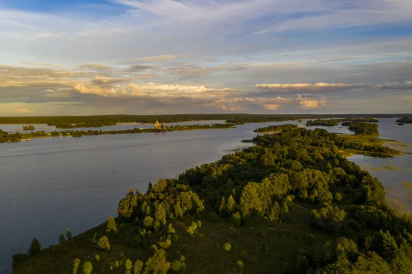 一つの島に多くの島がある湖のパノラマビュー無人機から撮影された日没時に木で作られた古代の寺院があります — ストック写真