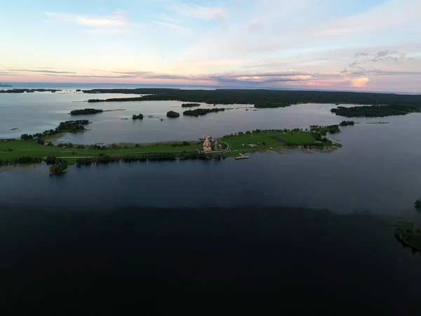 一つの島に多くの島がある湖のパノラマビュー無人機から撮影された日没時に木で作られた古代の寺院があります — ストック写真