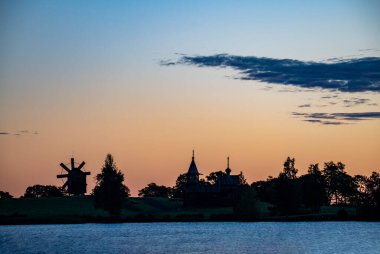 Gölün arka planında, gün doğumunda adadaki klasik kiliseler