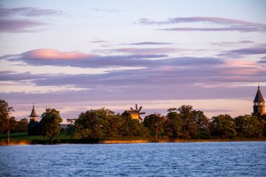 Gölün arka planında, gün doğumunda adadaki klasik kiliseler