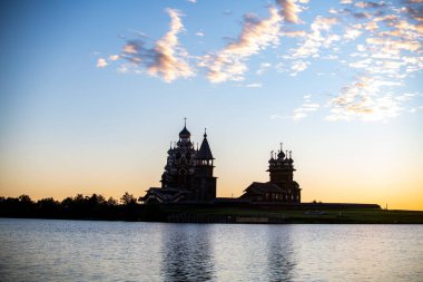 Gölün arka planında, gün doğumunda adadaki klasik kiliseler