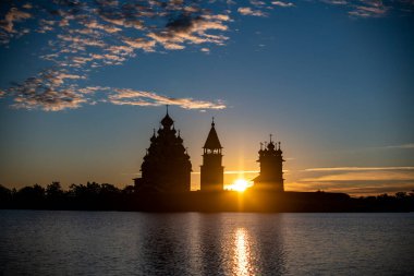 Gölün arka planında, gün doğumunda adadaki klasik kiliseler