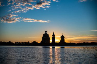 Gölün arka planında, gün doğumunda adadaki klasik kiliseler