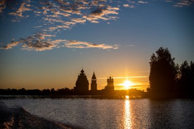 Gölün arka planında, gün doğumunda adadaki klasik kiliseler