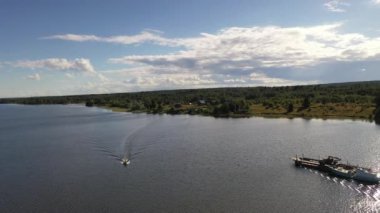 Göl üzerindeki yeşil adaların panoramik bir görüntüsü. Eski mimari yapıları olan gemiler insansız hava aracından çekiliyor.