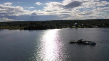 Göl üzerindeki yeşil adaların panoramik bir görüntüsü. Eski mimari yapıları olan gemiler insansız hava aracından çekiliyor.