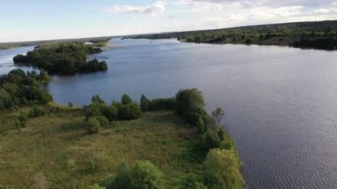 Göl üzerindeki yeşil adaların panoramik bir görüntüsü. Eski mimari yapıları olan gemiler insansız hava aracından çekiliyor.