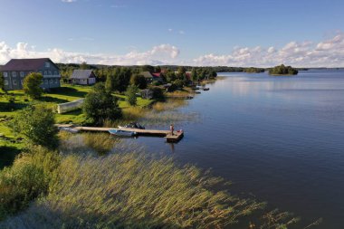 Göldeki bir adanın yeşilliğinin panoramik görüntüsü. İnsansız hava aracından çekilen antik mimari yapılar.