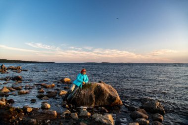 Mavi bulutların arka planında deniz ve kıyı şeridi olan manzara ve kuzey adasında batan güneş