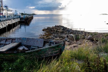 Adanın manzarası kıyıda duran eski ahşap teknelerin arka planına karşı