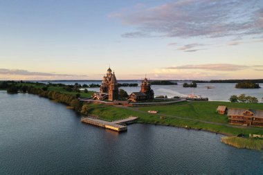 Göl kenarındaki eski ahşap binalarla adanın panoramik görüntüsü insansız hava aracından çekiliyor.