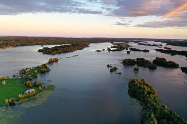 Göl kenarındaki eski ahşap binalarla adanın panoramik görüntüsü insansız hava aracından çekiliyor.