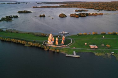 Göl kenarındaki eski ahşap binalarla adanın panoramik görüntüsü insansız hava aracından çekiliyor.