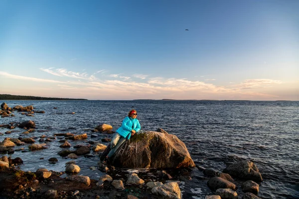 Mavi bulutların arka planında deniz ve kıyı şeridi olan manzara ve kuzey adasında batan güneş