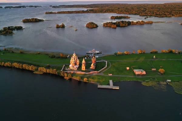 Göl kenarındaki eski ahşap binalarla adanın panoramik görüntüsü insansız hava aracından çekiliyor.