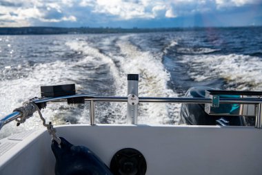 Mavi suların ve mavi gökyüzünün arka planında yüksek süratli bir teknenin yanından geçen gemilerin bulunduğu adalar.