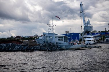Mavi suların ve mavi gökyüzünün arka planında yüksek süratli bir teknenin yanından geçen gemilerin bulunduğu adalar.