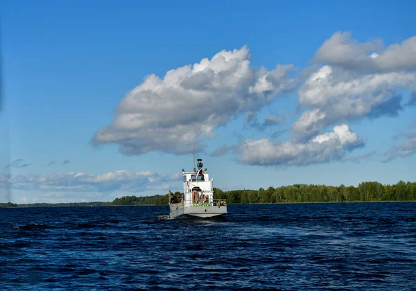 青い水と青い空を背景に高速船の横から島が通過する風景 — ストック写真