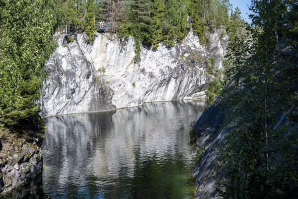Granitte temiz yeşil su ve doğal bir anıtta mermer kayalar olan dağ gölü.