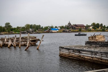 Güneşin doğuşunda eski ahşap liman, taş ve deniz manzarası