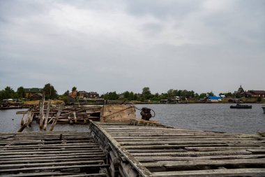 Güneşin doğuşunda eski ahşap liman, taş ve deniz manzarası