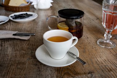 Kahverengi bir masada çay ve turtalarla kahvaltı