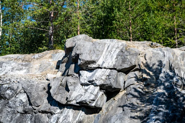 Doğal bir anıtın çam ormanında işlenmiş mermer bloklar.