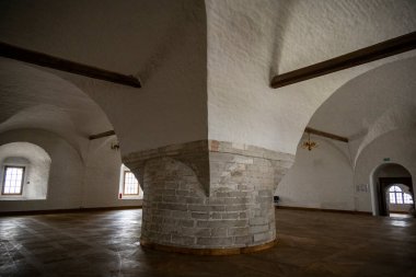 Yağmurlu bir gökyüzünün arka planında kuleleri ve iç binaları olan eski bir taş kale manastırı.