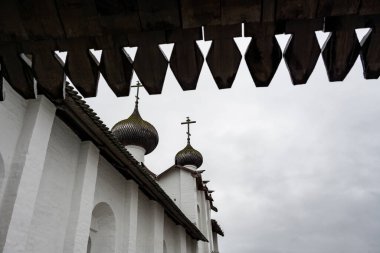 Yağmurlu bir gökyüzünün arka planında kuleleri ve iç binaları olan eski bir taş kale manastırı.