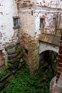 Yağmurlu bir gökyüzünün arka planında kuleleri ve iç binaları olan eski bir taş kale manastırı.