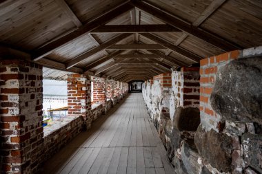 Yağmurlu bir gökyüzünün arka planında kuleleri ve iç binaları olan eski bir taş kale manastırı.