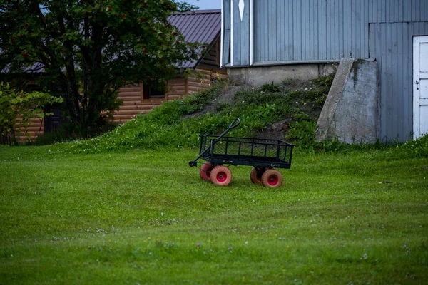 trolley for transporting household goods on a green lawn near the house