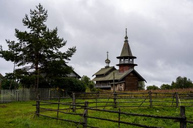 Yağmur sırasında ağaçların arasında, adadaki eski ahşap kilise.