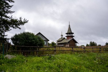 Yağmur sırasında ağaçların arasında, adadaki eski ahşap kilise.