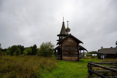 Yağmur sırasında ağaçların arasında, adadaki eski ahşap kilise.
