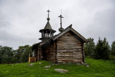Beyaz yağmurluklu bir kadın, kimsenin yaşamadığı bir adada manzaraya aşina olur.