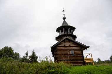 Yağmur sırasında ağaçların arasında, adadaki eski ahşap kilise.