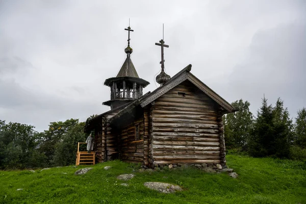Beyaz yağmurluklu bir kadın, kimsenin yaşamadığı bir adada manzaraya aşina olur.