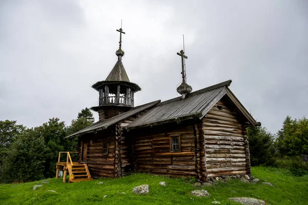 Yağmur sırasında ağaçların arasında, adadaki eski ahşap kilise.